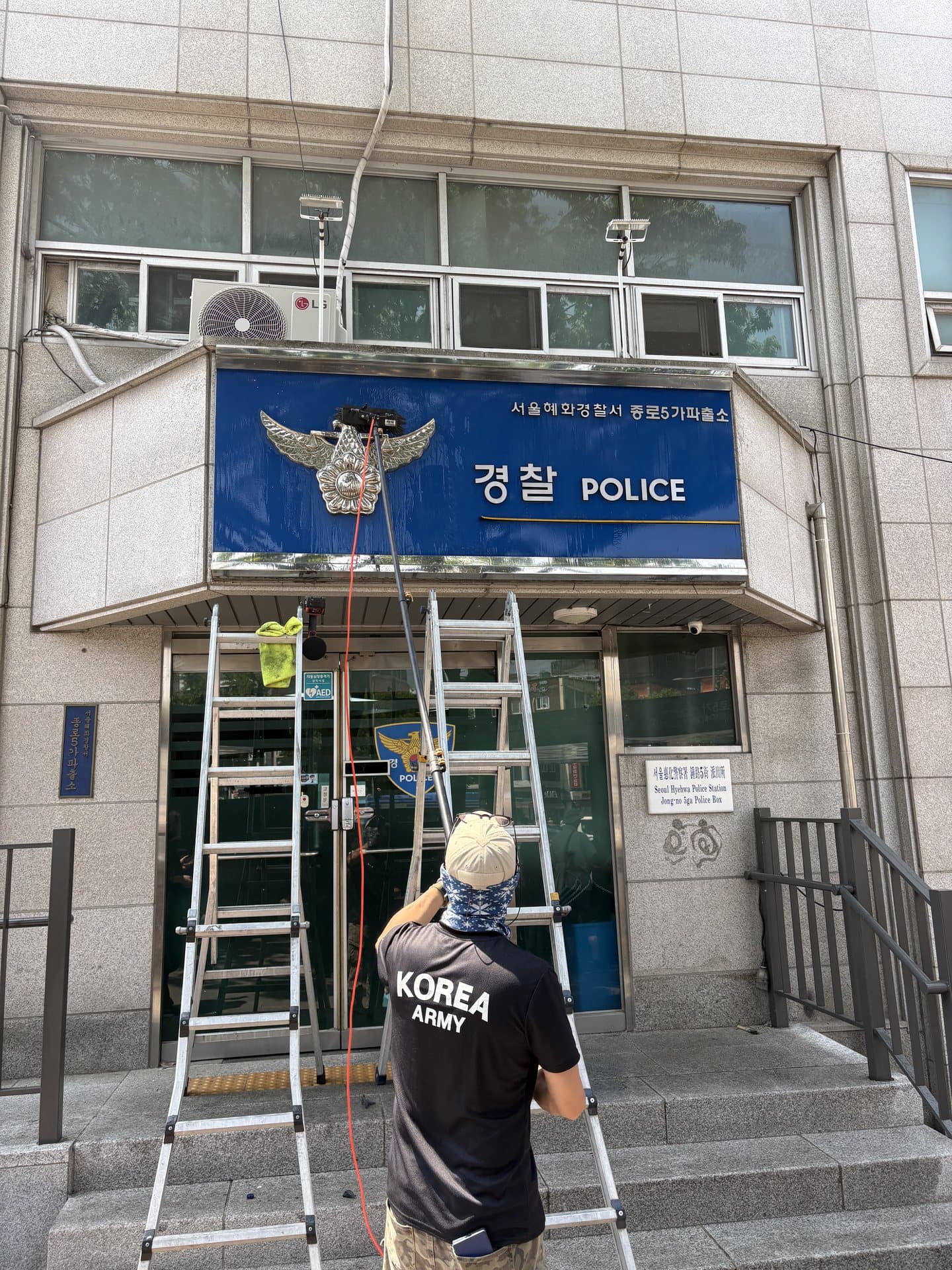매장 간판을 청소하는 클린덕 작업자